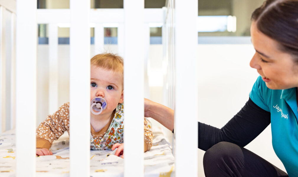 Educator putting a child down for a nap at Lochinvar early education centre