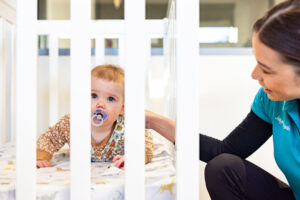 Educator putting a child down for a nap at Lochinvar early education centre