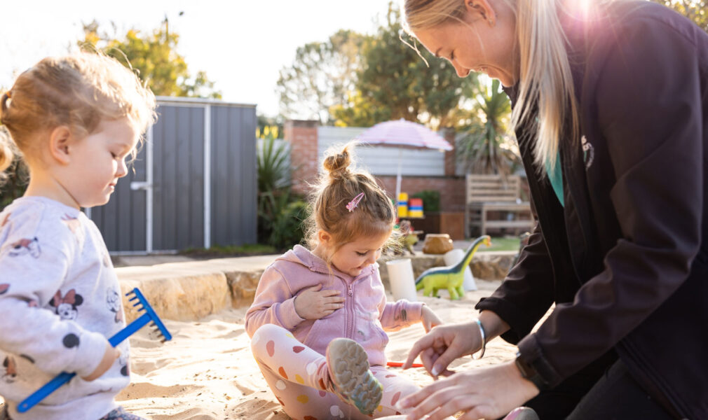 Children and educator in sand pit outside at Lochinvar early education centre