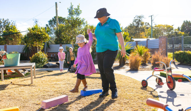Child and educator in outdoor environment at Lochinvar early education centre