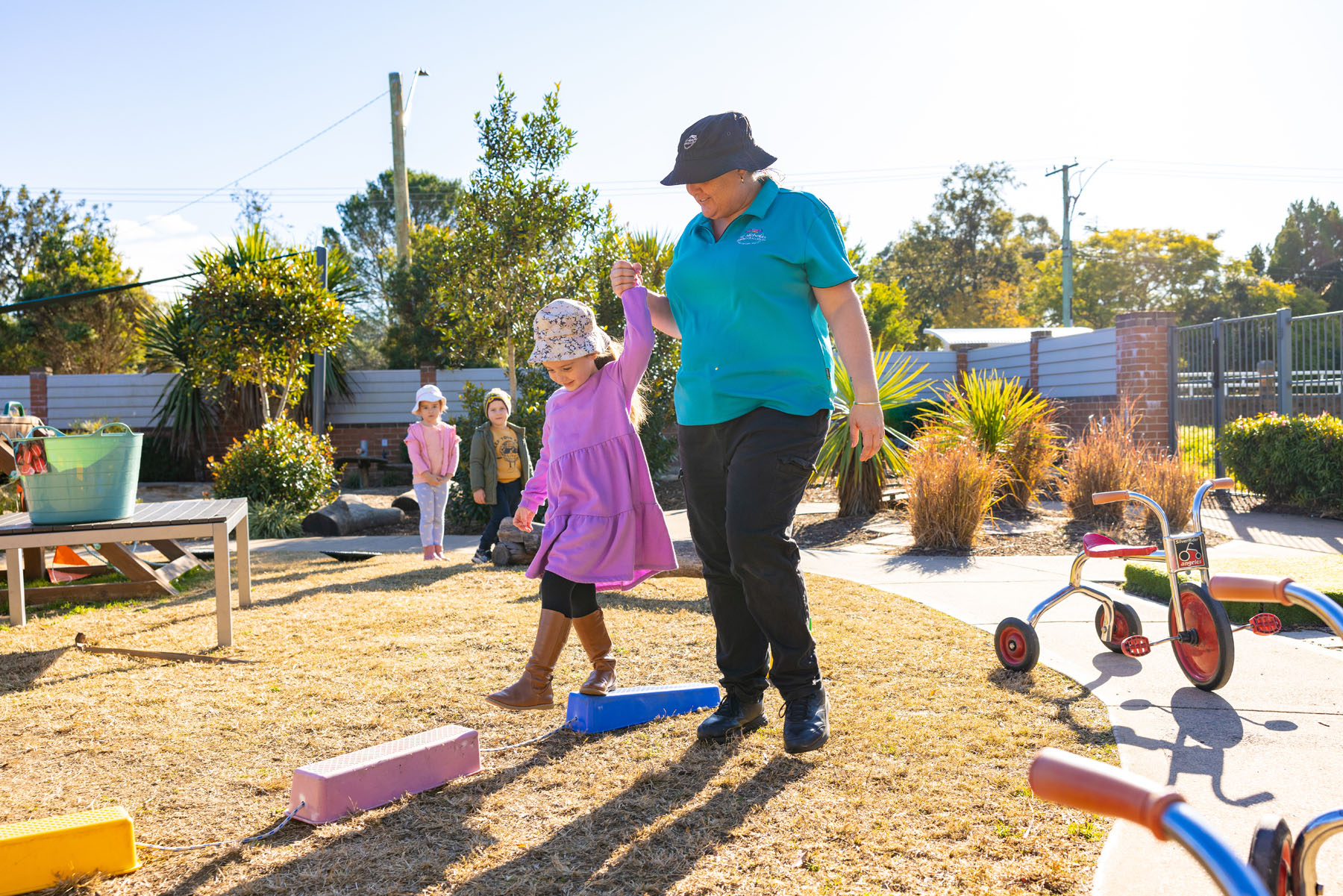 Child and educator in outdoor environment at Lochinvar early education centre