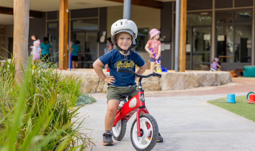 Child on bike in playground at Branxton early education centre