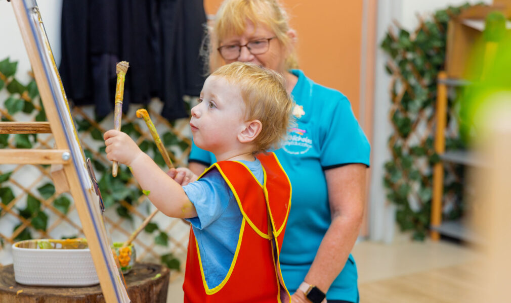 Child and educator painting together at Chisholm early education centre