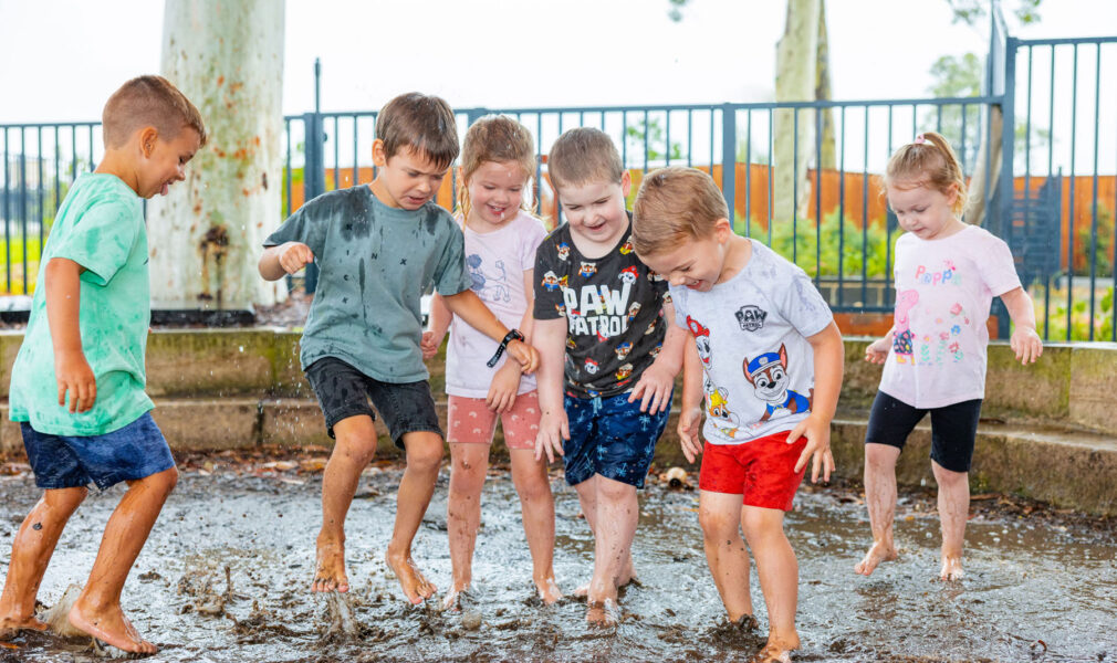 Children playing in the mud pit at Chisholm early education centre