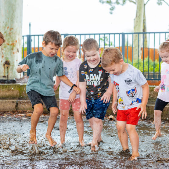 Children playing in the mud pit at Chisholm early education centre