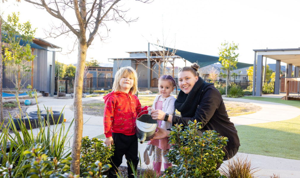 Children and educator watering gardens at Gillieston Heights early education centre