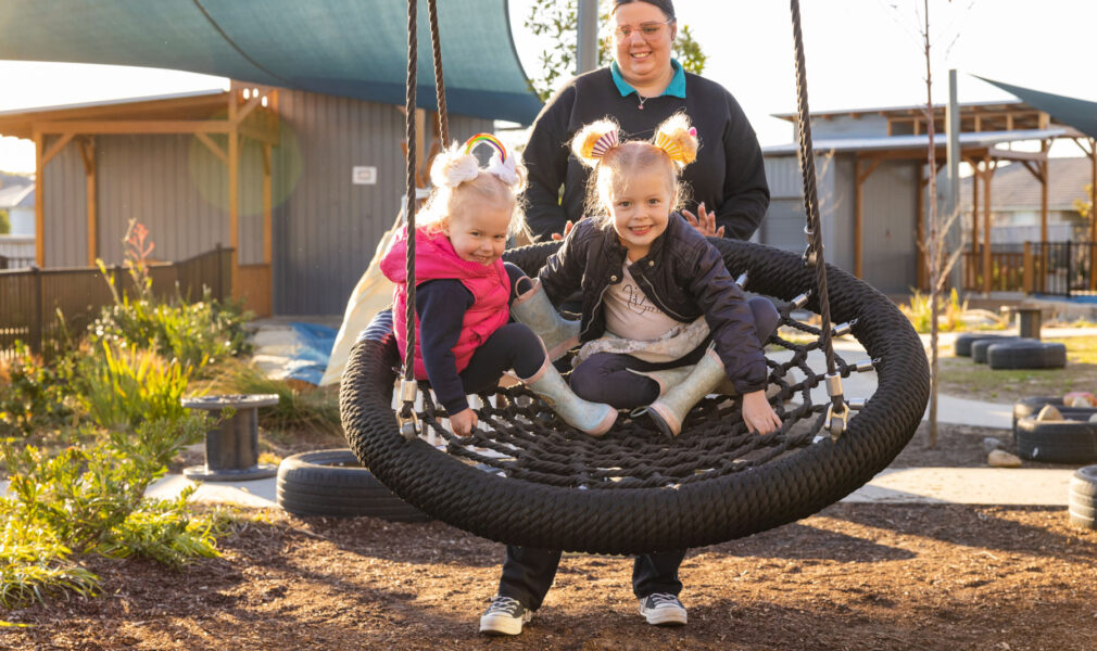 Children and educator on swing at Gillieston Heights early education centre