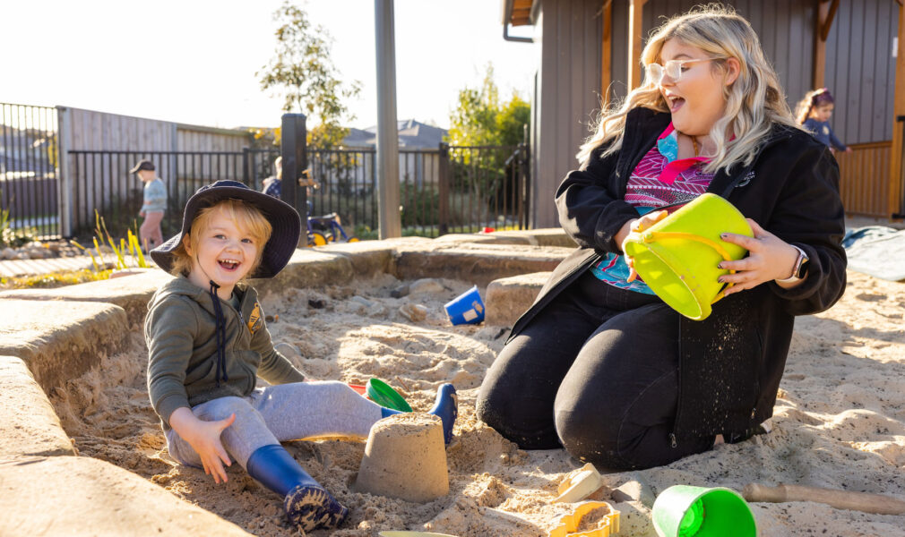 Child and educator in sand pit at Gillieston Heights early education centre