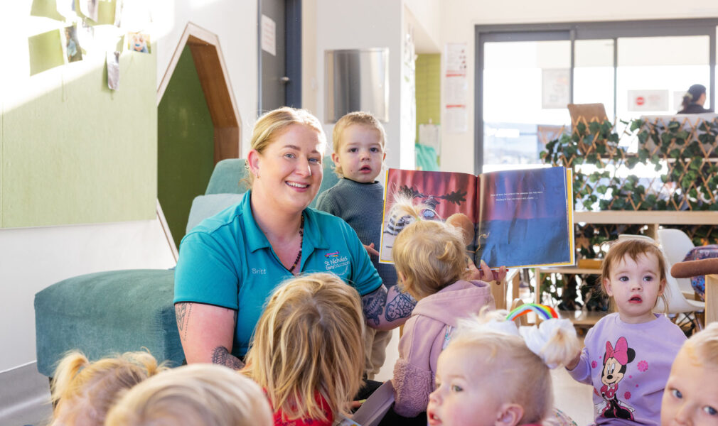 Children and educator reading a book at Gillieston Heights early education centre