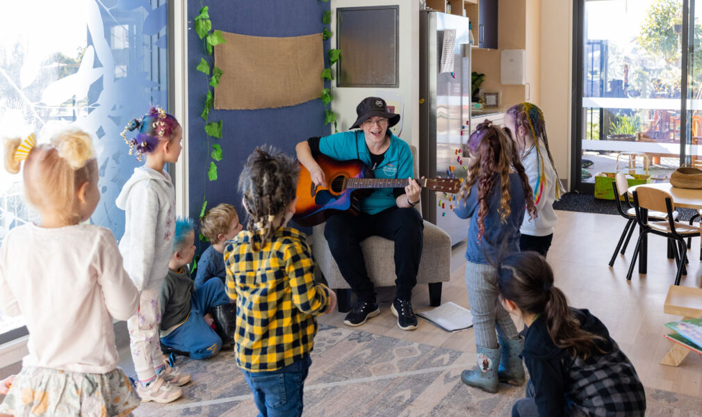 Children and educator singing and dancing with guitar at Gillieston Heights early education centre