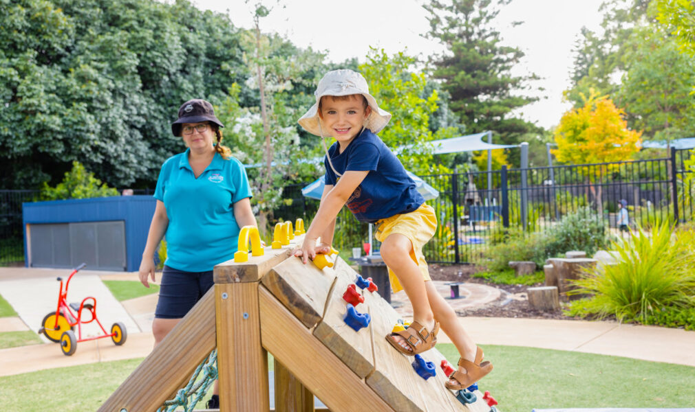 Child and educator playing on a climbing structure at Maitland early education centre