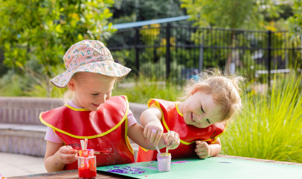 Children painting outside together at Maitland early education centre