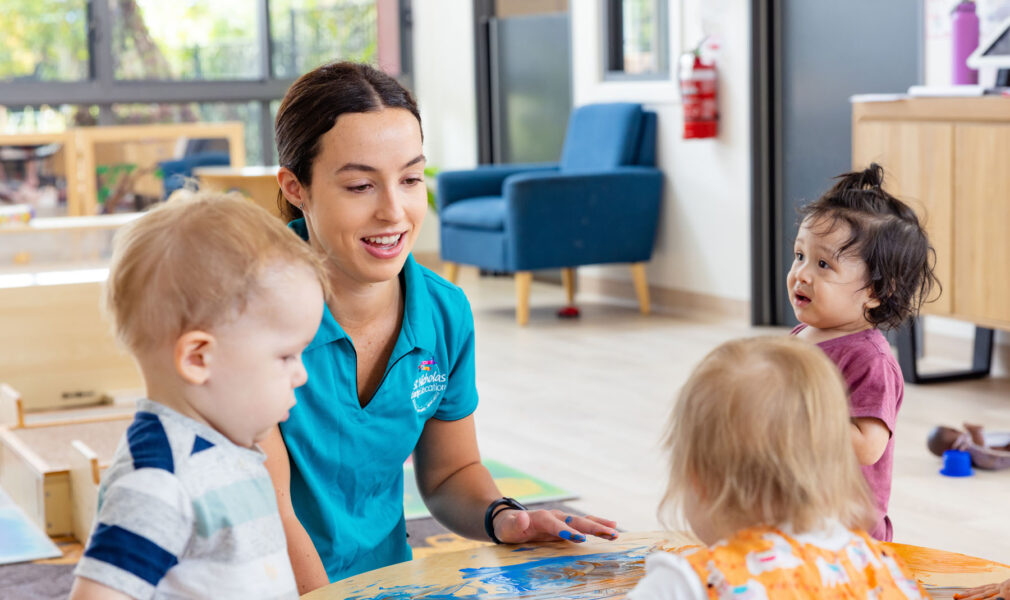 Children and educator painting on table at Maitland early education centre