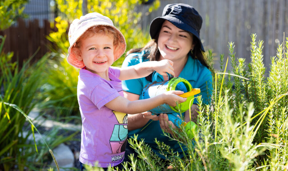 Child and educator tending to gardens at Medowie early education centre