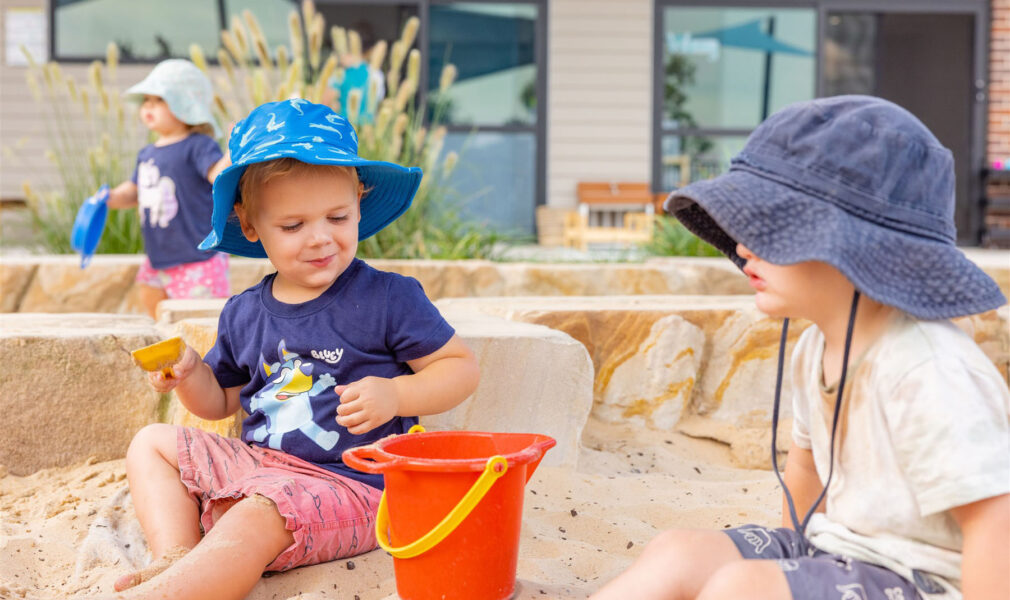 Children playing in sandpit together outside at Muswellbrook early education centre