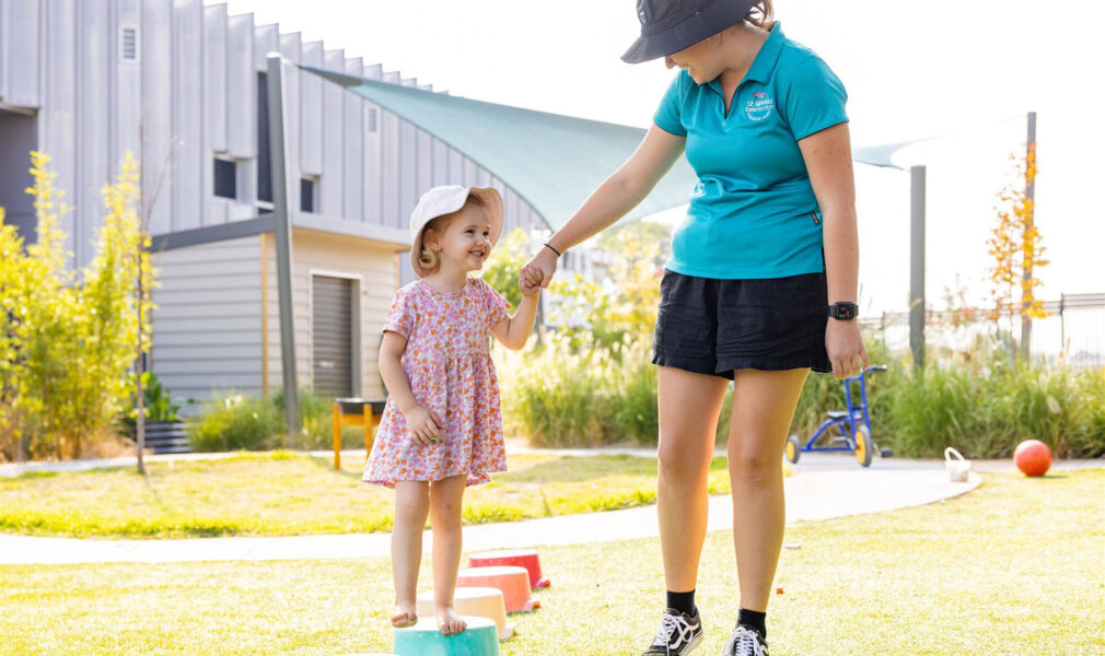 Child and educator walking together outside at Muswellbrook early education centre