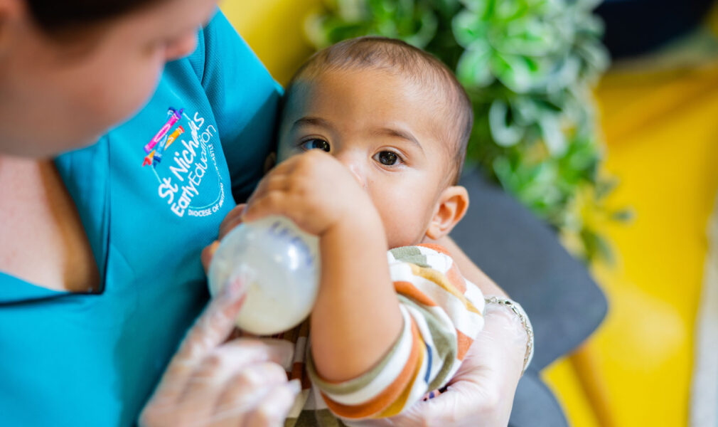 Educator feeding a child a bottle at Newcastle West early education centre