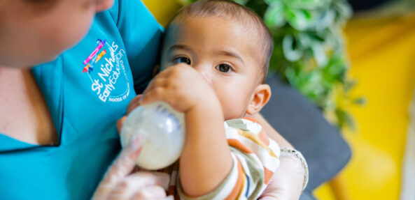 Educator feeding a child a bottle at Newcastle West early education centre