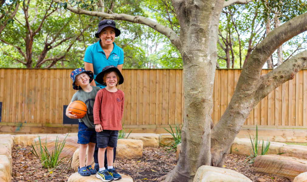 Educator and children playing in gardens together outside at Newcastle West early education centre