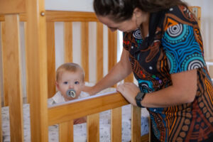 Educator putting a child down for a nap at Raymond Terrace early education centre