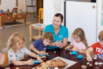 Educator and children playing with play dough together at Raymond Terrace early education centre