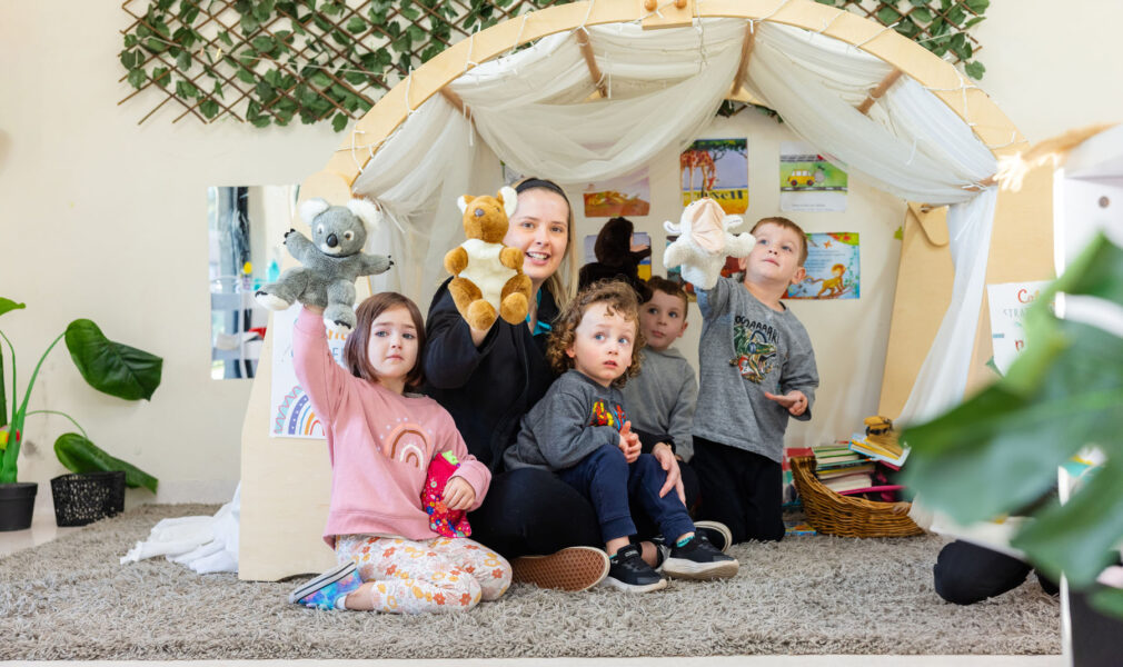 Children and educator playing with puppets inside at Singleton early education centre