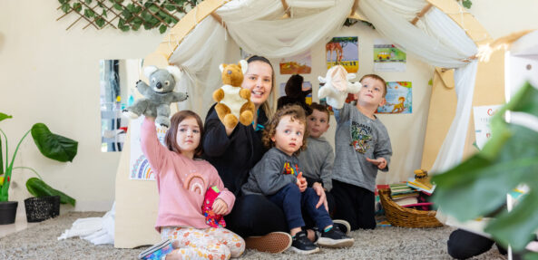 Children and educator playing with puppets inside at Singleton early education centre