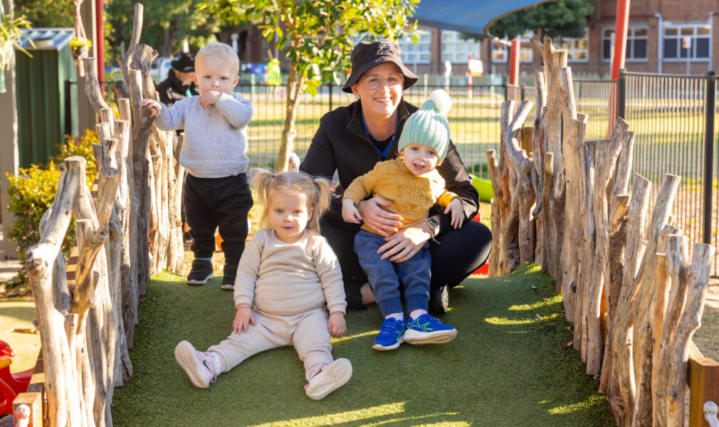 Children and educator playing on structure outside at Singleton early education centre