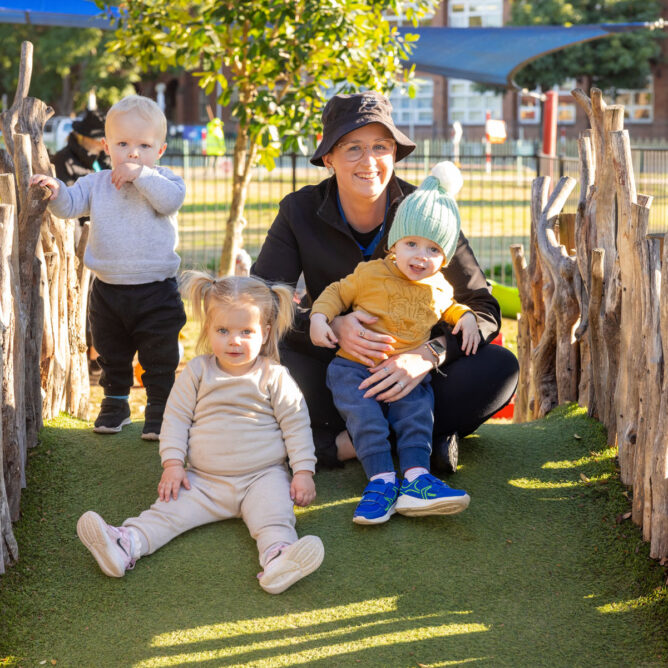 Children and educator playing on structure outside at Singleton early education centre