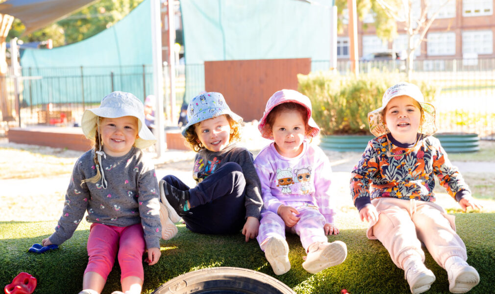 Children sitting together outside at Singleton early education centre