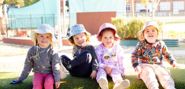 Children sitting together outside at Singleton early education centre
