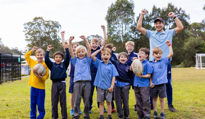 A St Nicholas OOSH Educator cheering with a group of children outside