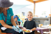 A child care cook with St Nicholas Early Education serving a child food