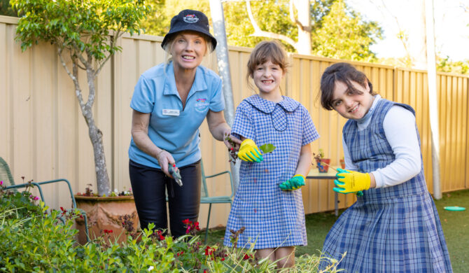 A St Nicholas OOSH Educator gardening with some children